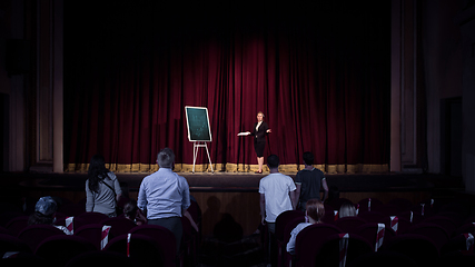 Image showing Female caucasian speaker giving presentation in hall at university or business centre workshop