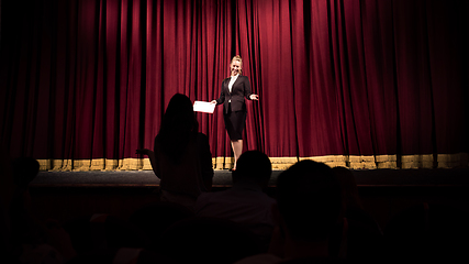 Image showing Female caucasian speaker giving presentation in hall at university or business centre workshop