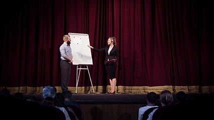 Image showing Female caucasian speaker giving presentation in hall at university or business centre workshop