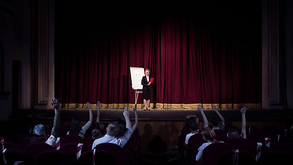 Image showing Female caucasian speaker giving presentation in hall at university or business centre workshop