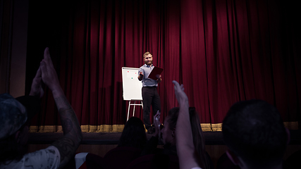 Image showing Male caucasian speaker giving presentation in hall at university or business centre workshop