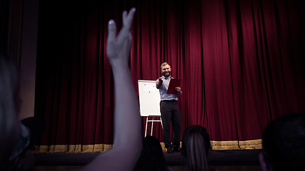 Image showing Male caucasian speaker giving presentation in hall at university or business centre workshop