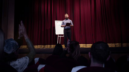 Image showing Male caucasian speaker giving presentation in hall at university or business centre workshop