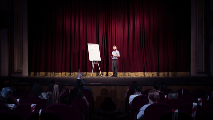 Image showing Male caucasian speaker giving presentation in hall at university or business centre workshop