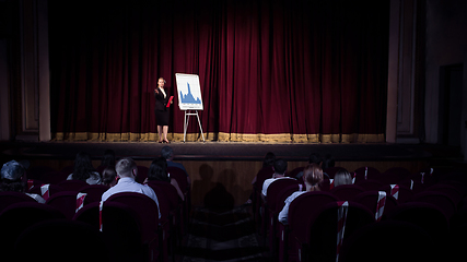 Image showing Female caucasian speaker giving presentation in hall at university or business centre workshop