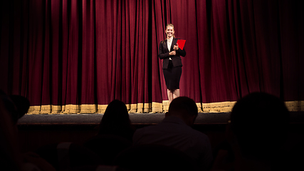 Image showing Female caucasian speaker giving presentation in hall at university or business centre workshop