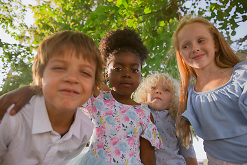 Image showing Interracial group of kids, girls and boys playing together at the park in summer day