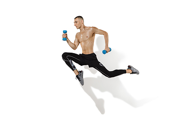 Image showing Beautiful young male athlete practicing on white studio background with shadows