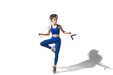 Image showing Beautiful young female athlete practicing on white studio background with shadows