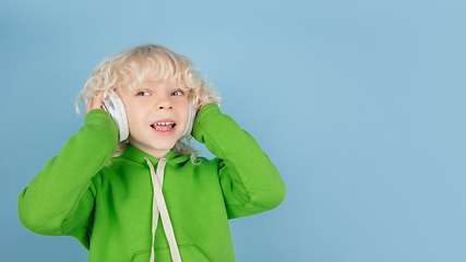 Image showing Portrait of beautiful caucasian little boy isolated on blue studio background