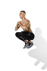 Image showing Beautiful young male athlete practicing on white studio background with shadows