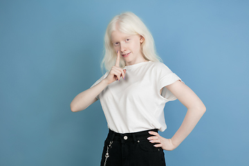 Image showing Portrait of beautiful caucasian albino girl isolated on blue studio background