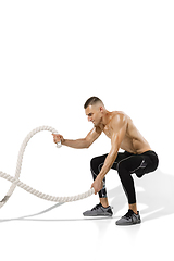 Image showing Beautiful young male athlete practicing on white studio background with shadows