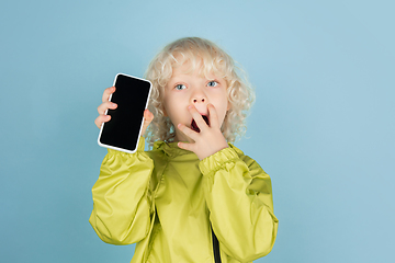 Image showing Portrait of beautiful caucasian little boy isolated on blue studio background