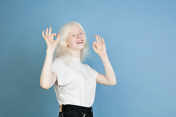 Image showing Portrait of beautiful caucasian albino girl isolated on blue studio background