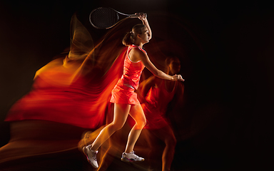 Image showing Professional female tennis player isolated on black studio background in mixed light