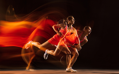 Image showing Professional female tennis player isolated on black studio background in mixed light