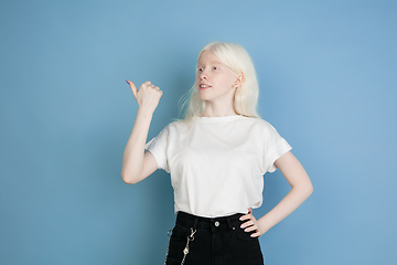 Image showing Portrait of beautiful caucasian albino girl isolated on blue studio background