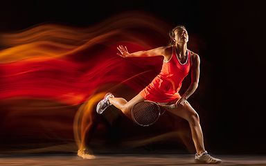 Image showing Professional female tennis player isolated on black studio background in mixed light