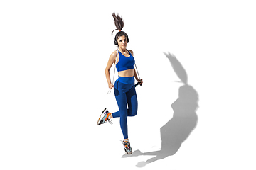 Image showing Beautiful young female athlete practicing on white studio background with shadows