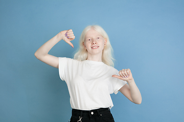 Image showing Portrait of beautiful caucasian albino girl isolated on blue studio background