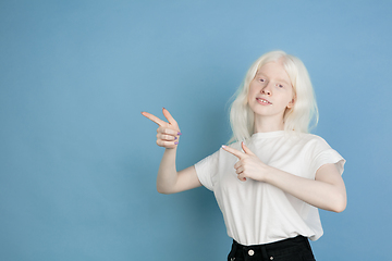 Image showing Portrait of beautiful caucasian albino girl isolated on blue studio background