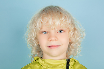 Image showing Portrait of beautiful caucasian little boy isolated on blue studio background