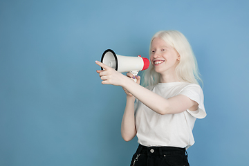 Image showing Portrait of beautiful caucasian albino girl isolated on blue studio background