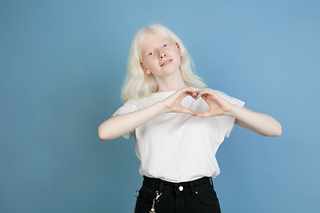 Image showing Portrait of beautiful caucasian albino girl isolated on blue studio background