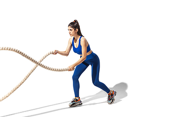 Image showing Beautiful young female athlete practicing on white studio background with shadows