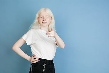 Image showing Portrait of beautiful caucasian albino girl isolated on blue studio background