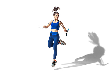 Image showing Beautiful young female athlete practicing on white studio background with shadows