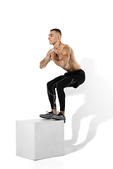 Image showing Beautiful young male athlete practicing on white studio background with shadows