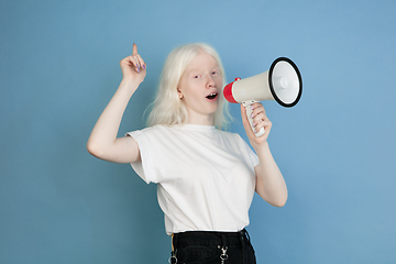 Image showing Portrait of beautiful caucasian albino girl isolated on blue studio background