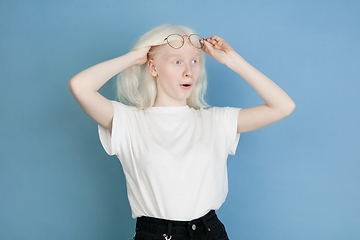 Image showing Portrait of beautiful caucasian albino girl isolated on blue studio background