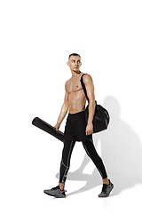 Image showing Beautiful young male athlete practicing on white studio background with shadows