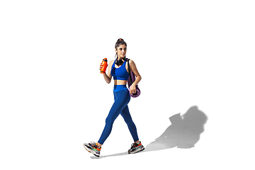 Image showing Beautiful young female athlete practicing on white studio background with shadows