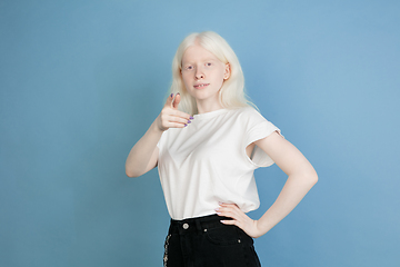 Image showing Portrait of beautiful caucasian albino girl isolated on blue studio background