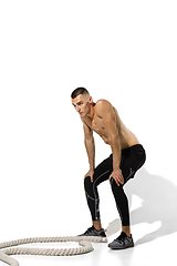 Image showing Beautiful young male athlete practicing on white studio background with shadows