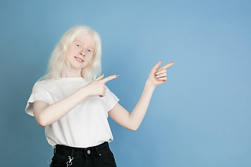 Image showing Portrait of beautiful caucasian albino girl isolated on blue studio background