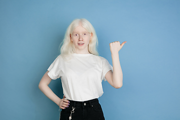 Image showing Portrait of beautiful caucasian albino girl isolated on blue studio background