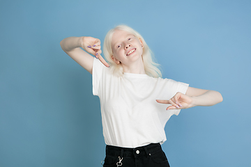 Image showing Portrait of beautiful caucasian albino girl isolated on blue studio background