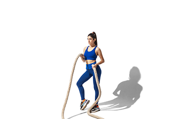 Image showing Beautiful young female athlete practicing on white studio background with shadows