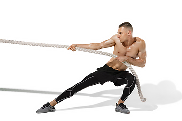 Image showing Beautiful young male athlete practicing on white studio background with shadows