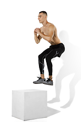 Image showing Beautiful young male athlete practicing on white studio background with shadows