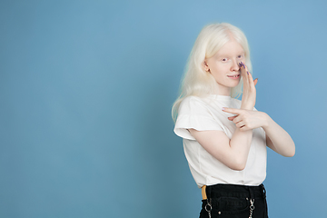 Image showing Portrait of beautiful caucasian albino girl isolated on blue studio background