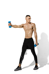 Image showing Beautiful young male athlete practicing on white studio background with shadows