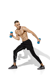 Image showing Beautiful young male athlete practicing on white studio background with shadows