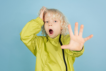 Image showing Portrait of beautiful caucasian little boy isolated on blue studio background