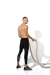 Image showing Beautiful young male athlete practicing on white studio background with shadows